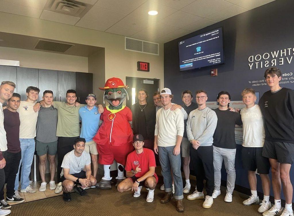 Alpha Sigma brothers pictured with Louie the Loon